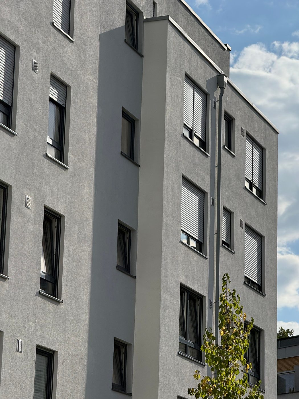 Wohngebäude mit modernen Fenstern und Rollläden